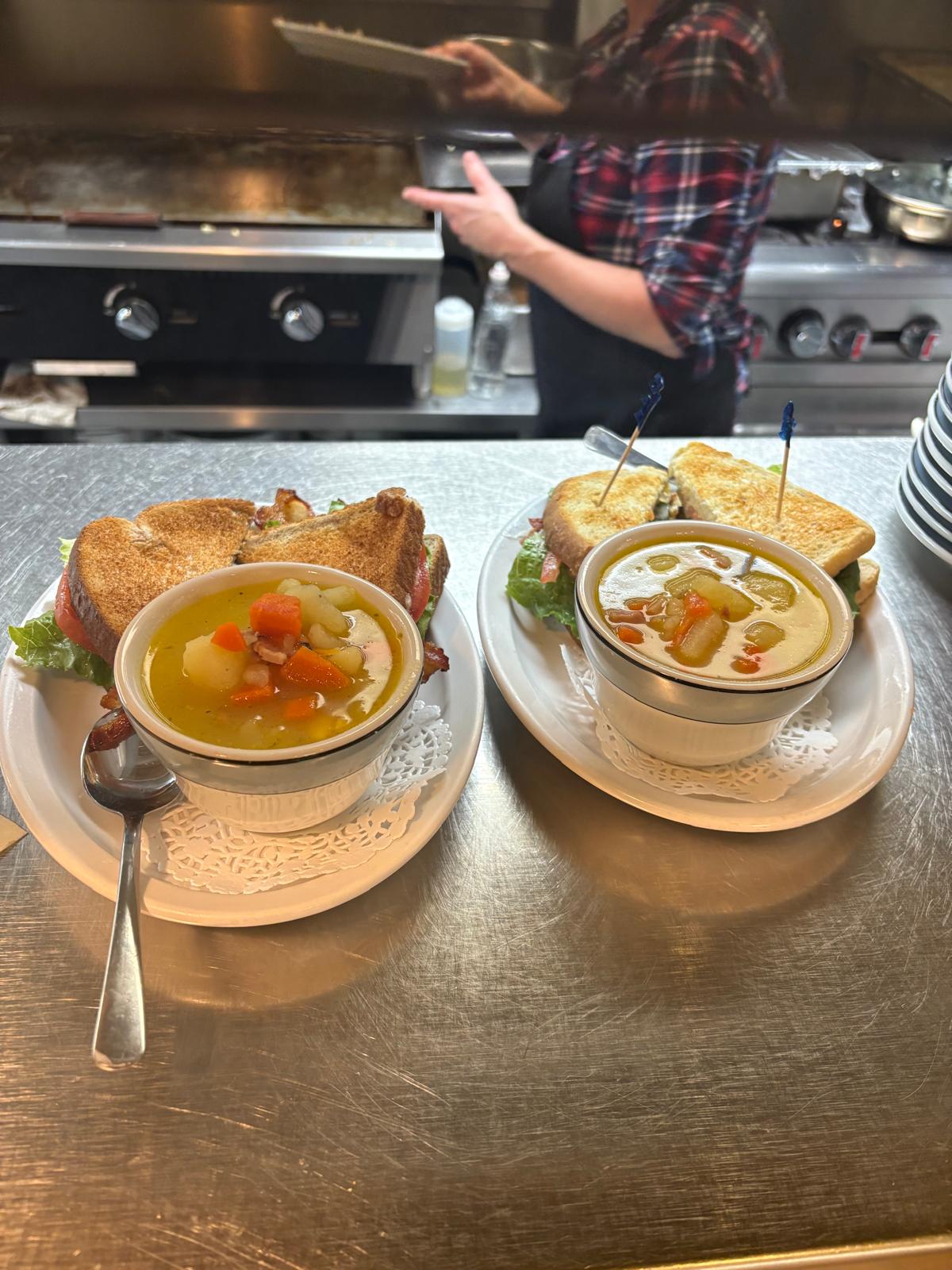Two combo plates at the kitchen pass with cook visible in the background